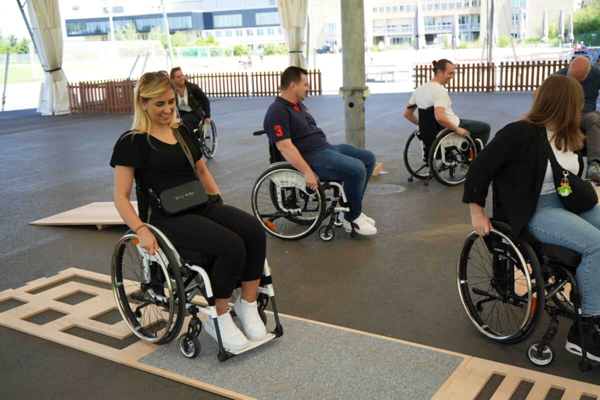 Mehrere Mitarbeiter, die ein Rollstuhl Parkur machen.